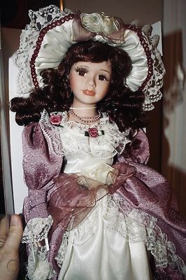 the doll is wearing a dress and hat