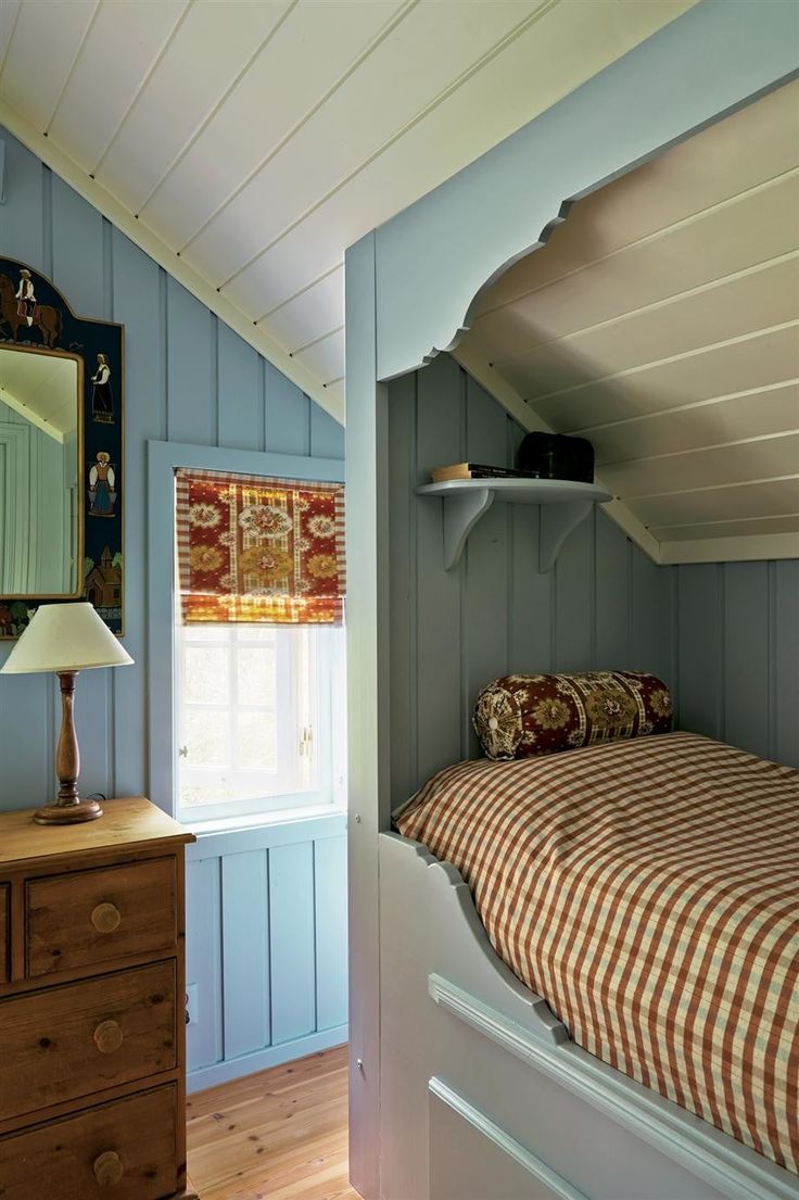 a bed sitting under a window next to a dresser