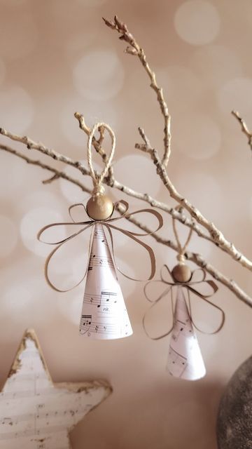 three bells hanging from a tree branch with music notes on them and a star ornament