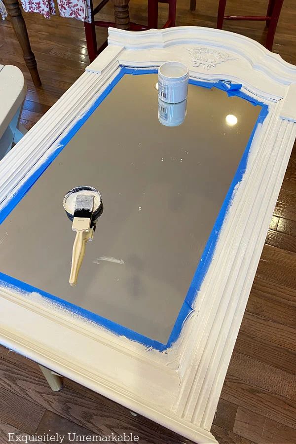 a white table with paint and a mirror on it that has a key in it