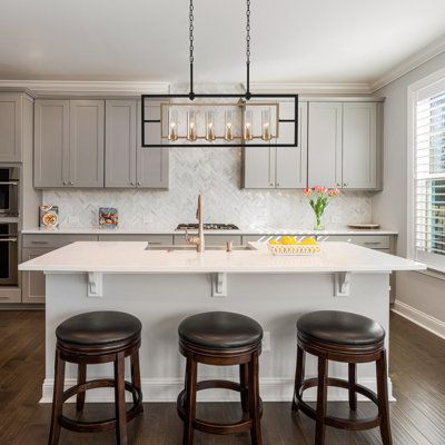 a kitchen island with three stools in front of it