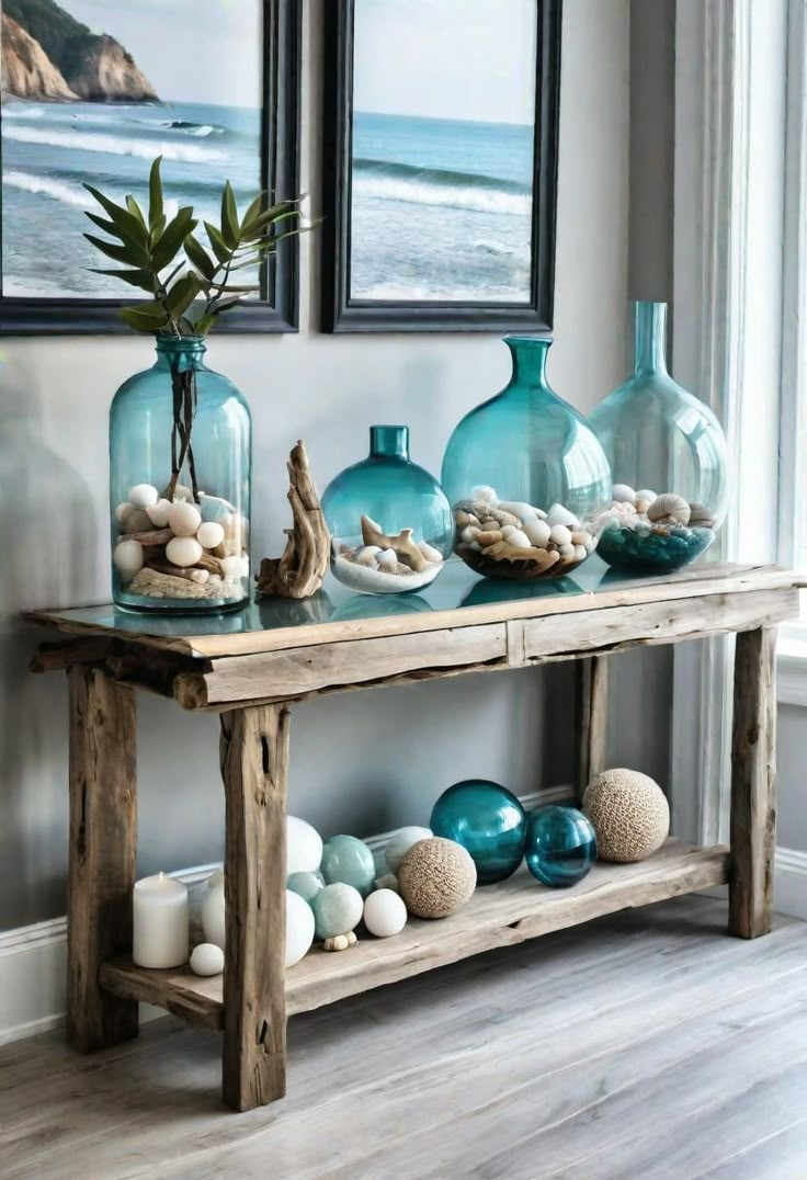 a table with vases and seashells on it in front of two framed pictures