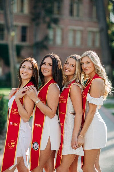 four beautiful women in white and red dresses posing for the camera with their sashs around their necks