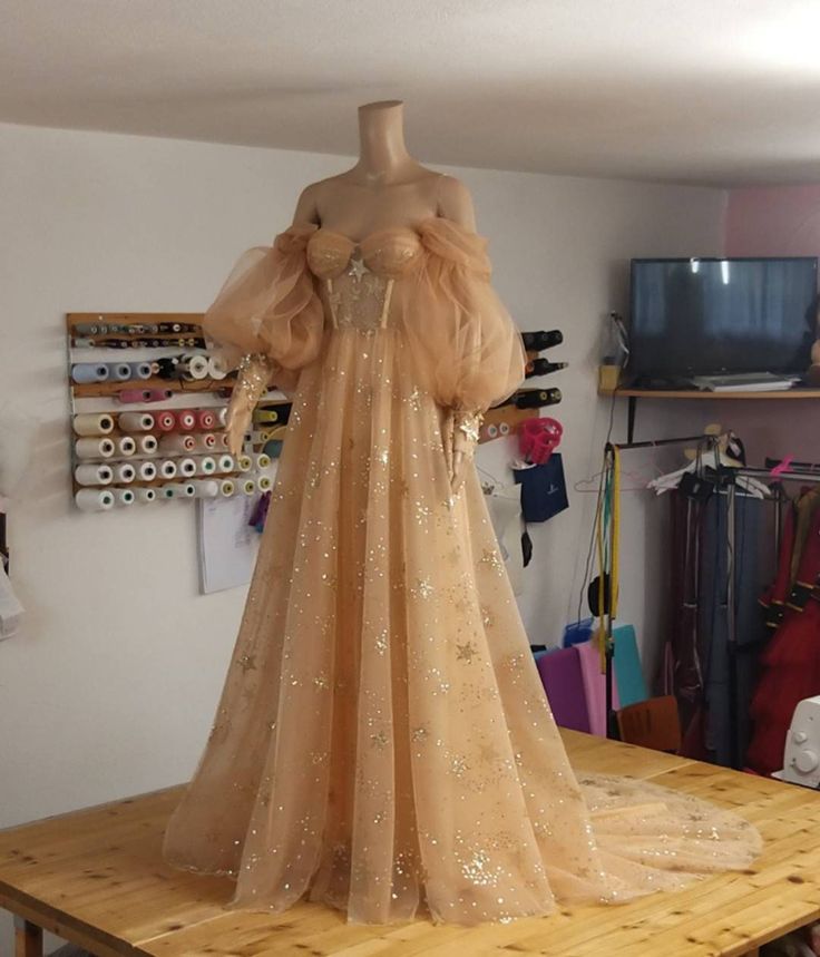 a mannequin dressed in gold sequins on a wooden table