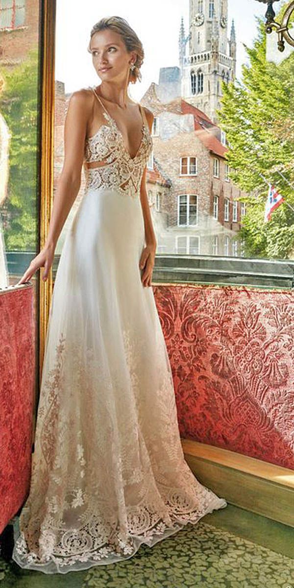 a woman in a white dress leaning against a stone wall with her hand on the railing