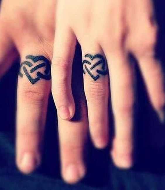 two fingers with tattoos on them and one has an arrow tattoo on the middle finger