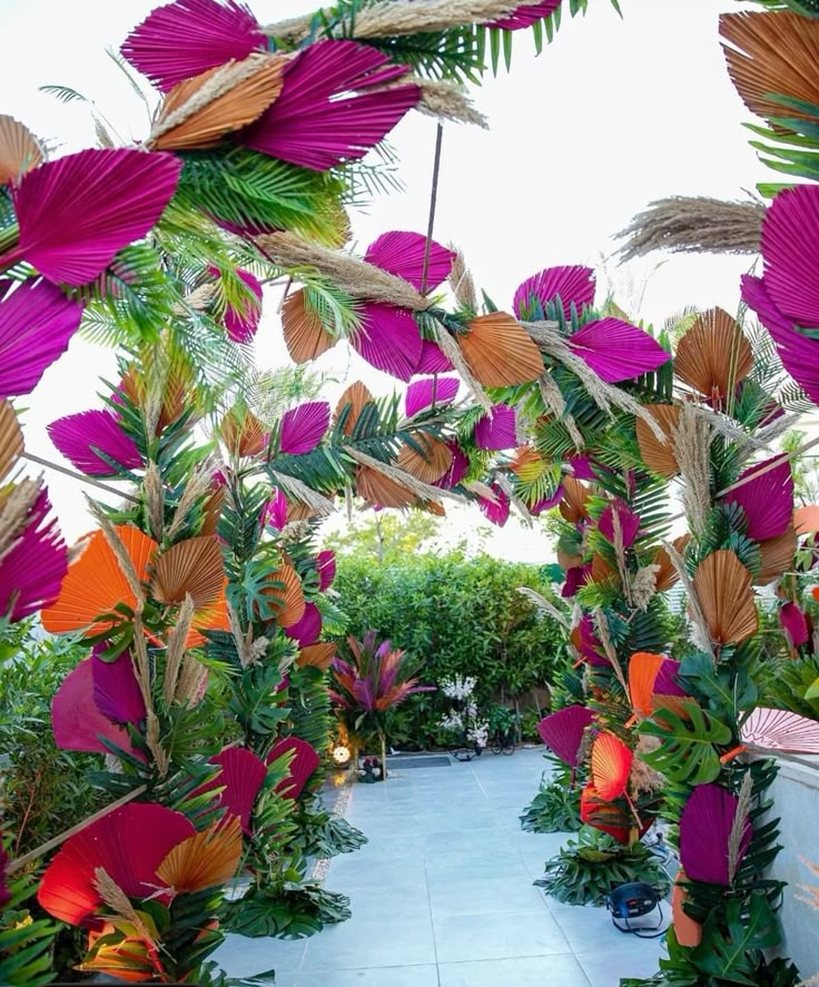 an outdoor area with lots of plants and flowers on the ground, including palm trees