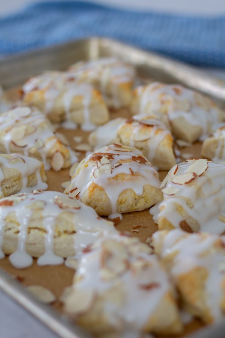 a pan filled with cinnamon rolls covered in icing and drizzled on top