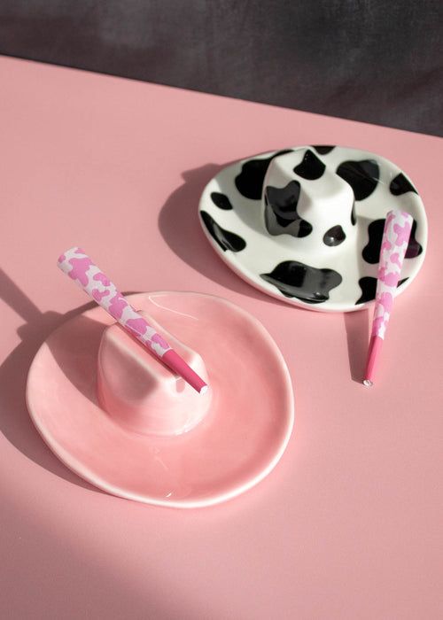 two plates with toothbrushes on them sitting on a pink table