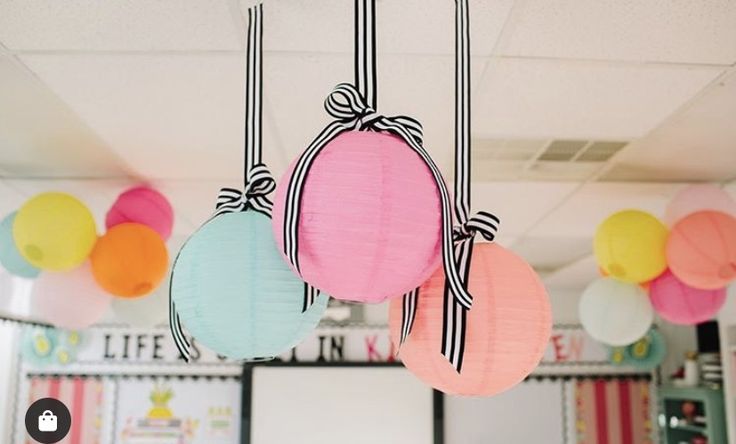 some paper lanterns hanging from the ceiling in a classroom