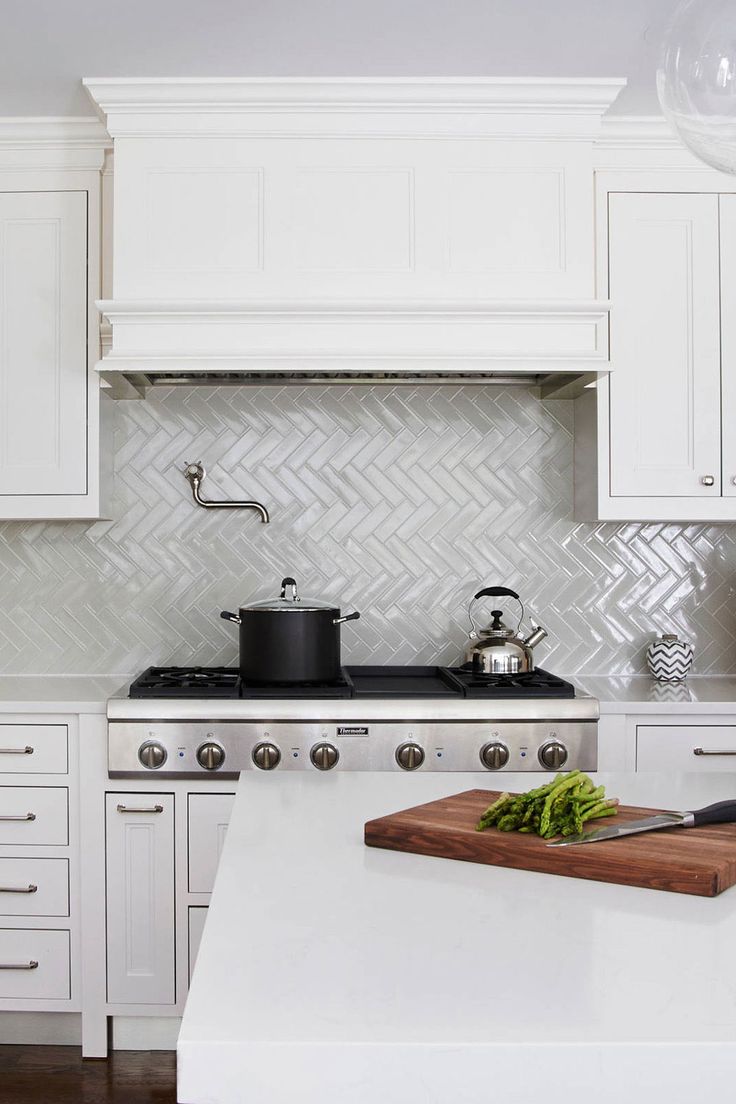 a kitchen with white cabinets and a wooden cutting board