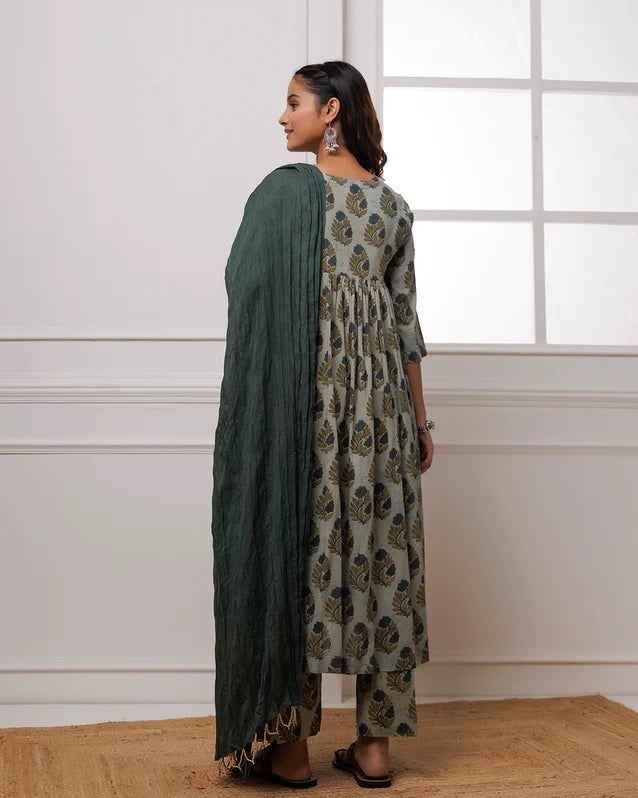 Experience luxury and elegance in our Forest Green Block Printed Suit Set. Crafted from fine mul-mul, this set showcases a classic traditional block print in a deep forest green hue. The set also includes a beautifully complementing dupatta adorned with delicate bead work along its edges. Elevate your wardrobe with this exclusive and timeless piece. No. of pieces - 3 piece set. Color - Green. Fabric - Mul-Mul, Cotton. Washing Instructions - Dry Clean. Green Kurta With Printed Motifs, Traditional Drape, Green Kurta With Printed Motifs, Elegant Green Anarkali Set For Transitional Season, Unstitched Green Anarkali Set For Formal Occasions, Green Anarkali Set For Eid Formal Occasion, Green Cotton Wedding Sets, Classic Eid Festive Sets, Classic Festive Sets For Eid, Green Cotton Palazzo Set For Wedding