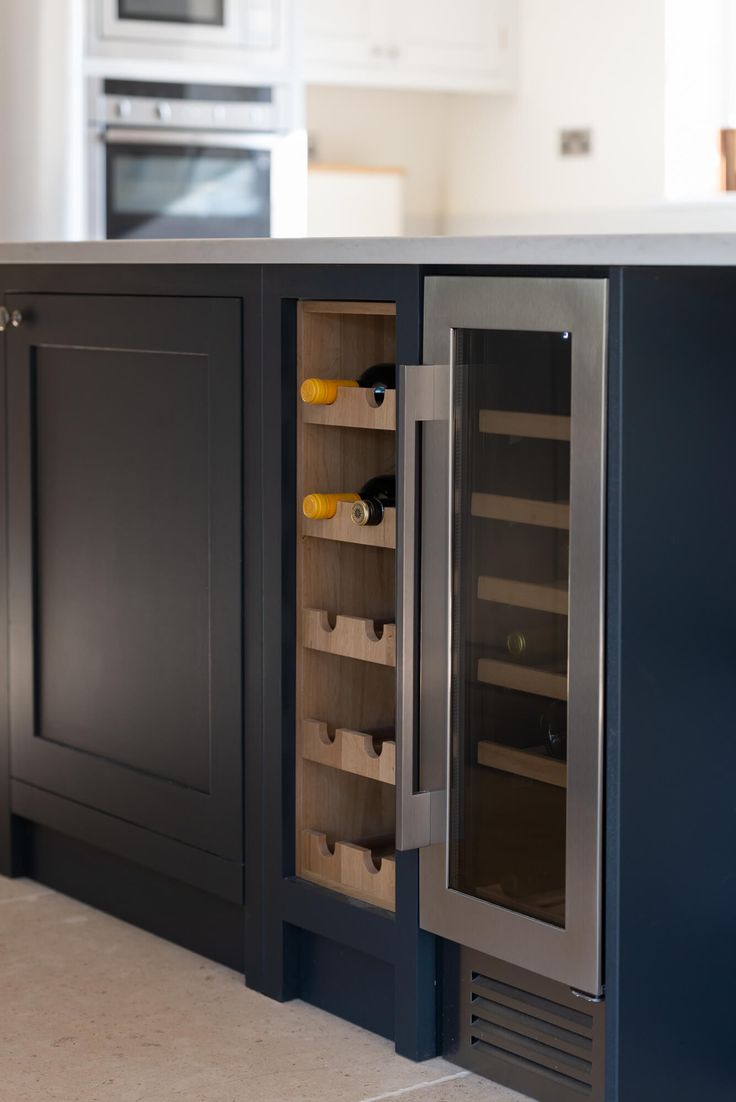 a wine cooler in the middle of a kitchen counter