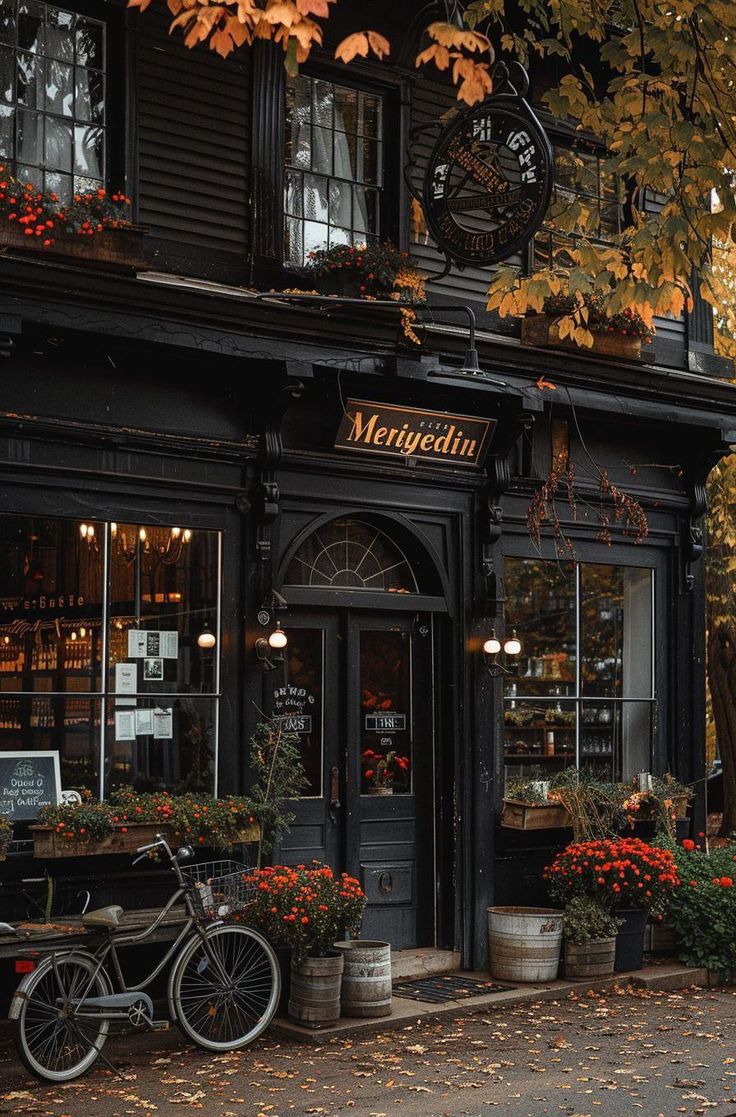 a bike is parked in front of a restaurant with autumn foliage on the windows and trees