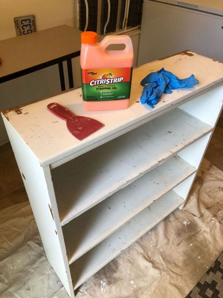 a bottle of cleaner sitting on top of a white shelf