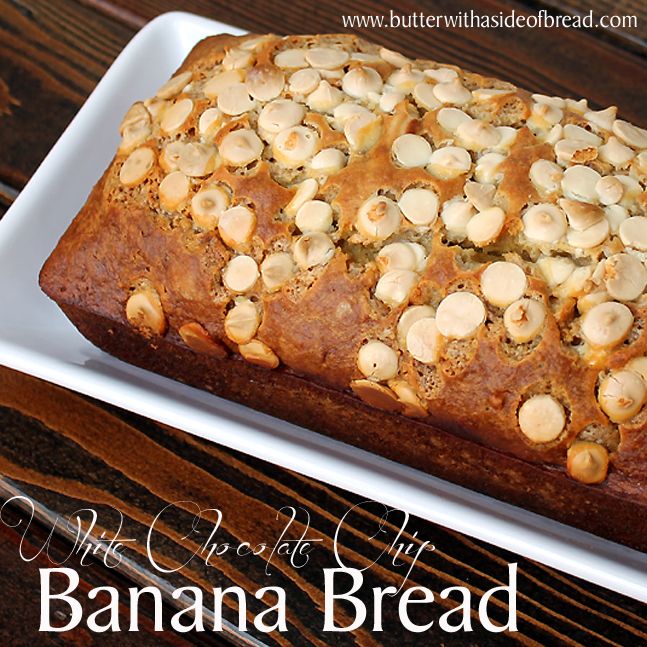 a loaf of banana bread sitting on top of a white plate next to a wooden table