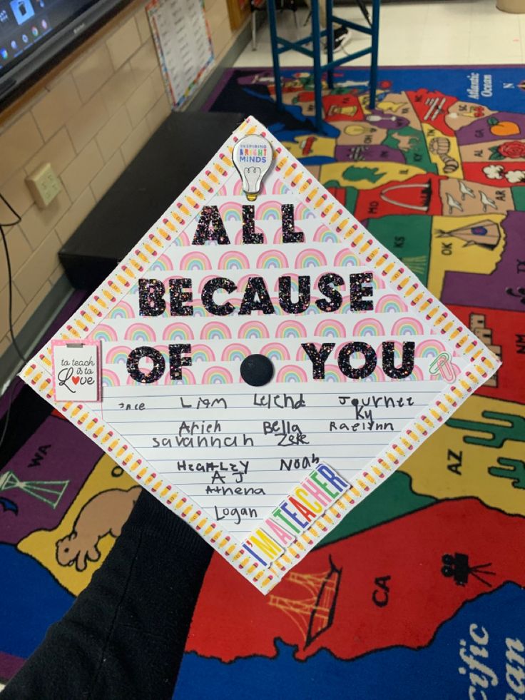 a graduation cap that says, all because of you on top of a colorful map