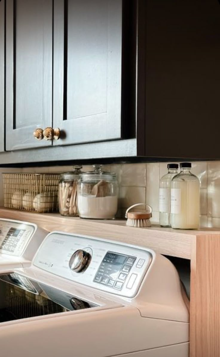 a washer and dryer sitting in a kitchen next to each other on the counter