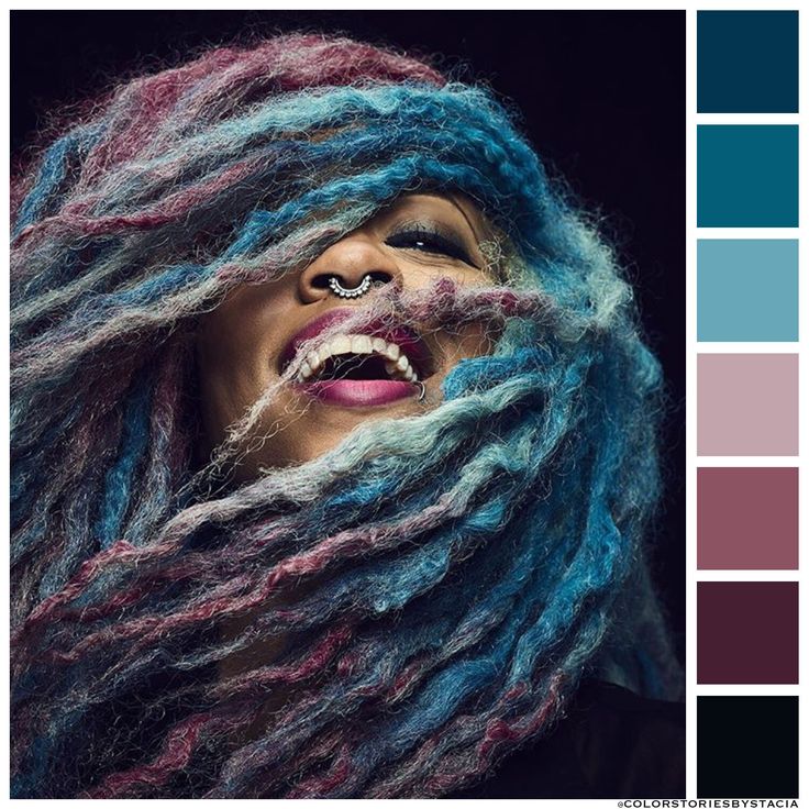 a woman with blue and pink dreadlocks on her face