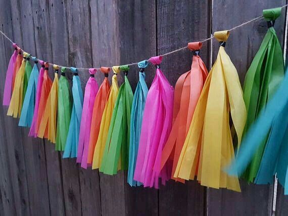 multicolored tissue tassels hanging on a wooden fence