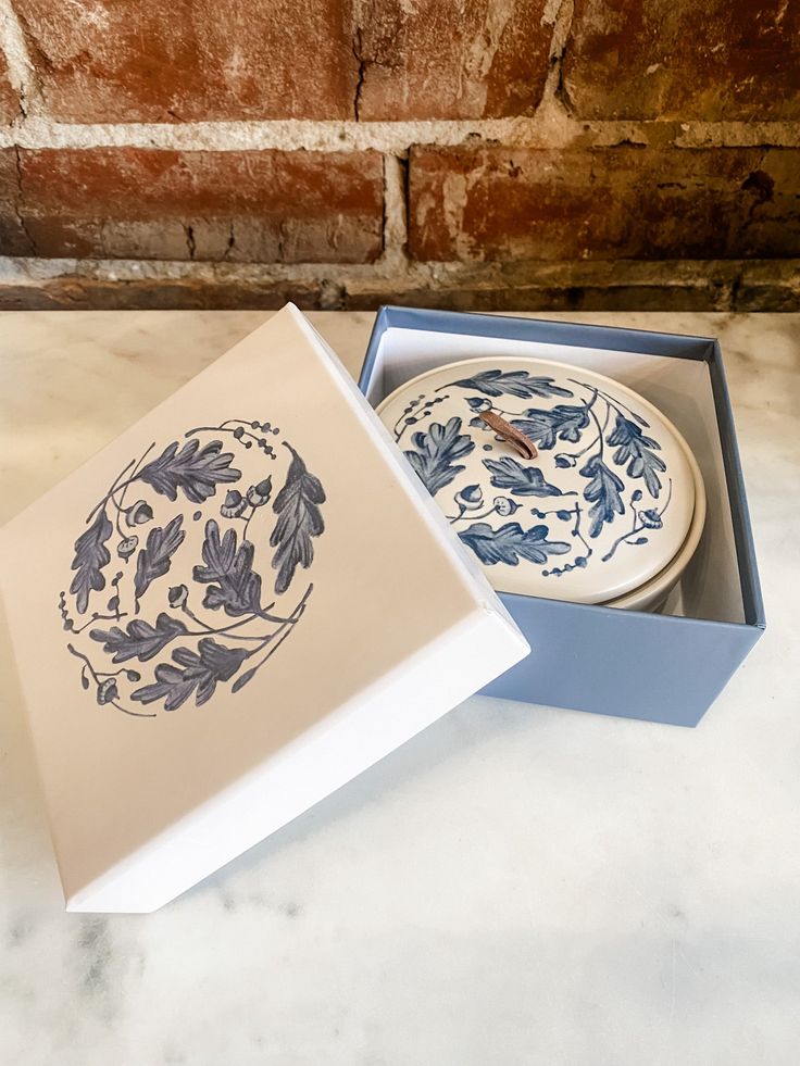 two plates in a box sitting on a marble counter top next to a brick wall