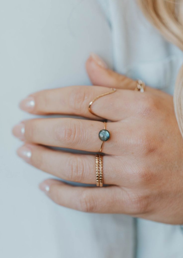 Our Dori ring is made with a gorgeous Labradorite stone. This mystical gemstone is believed to enhance mental clarity and bring about transformation. It's a crystal connected to the third eye chakra which is our gateway to inner wisdom and deeper intuition. 8mm round or 6x8mm oval labradorite stone. Ring band measures 1mm wide. Available in 14kt Gold Fill + Sterling Silver. KJ pairs it with our Sonder Ring, Raye Ring, and Confetti Ring. Handmade in Eau Claire, WI. Our jewelry is handmade so each Confetti Ring, Everyday Wear Jewelry, Backdrops Necklace, Zodiac Rings, The Third Eye, Hoop Charms, Inner Wisdom, Handmade Jewelry Designs, Third Eye Chakra