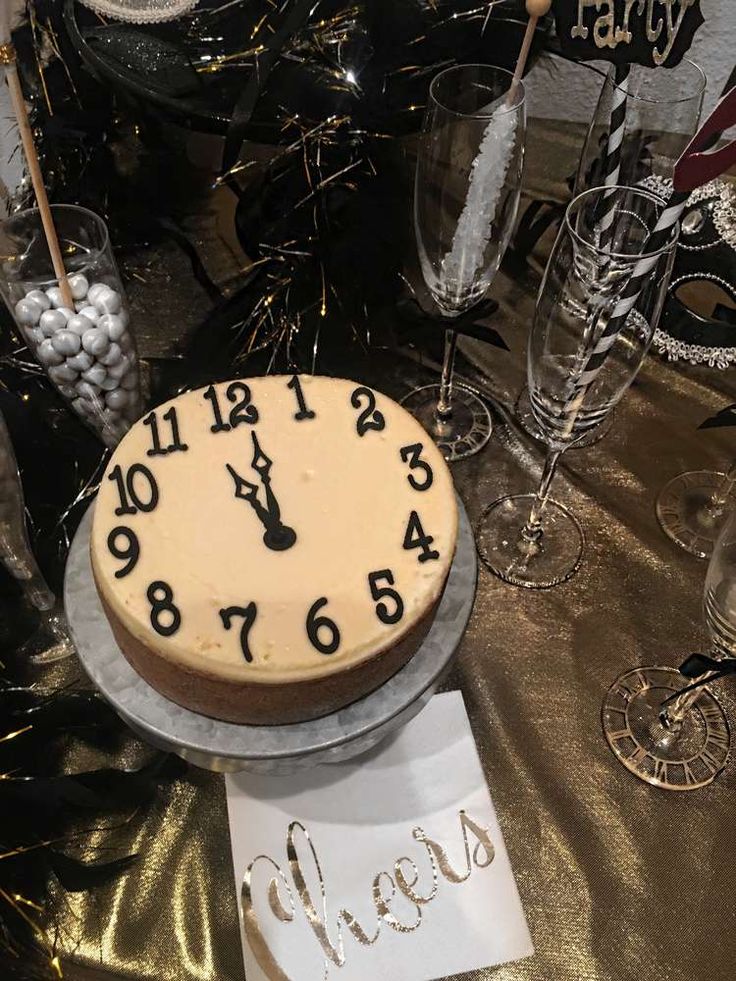 a cake that is sitting on top of a table with wine glasses and other decorations