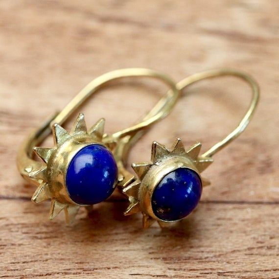 Vibrant gemstones were once said to spark of the flames of heaven. Hand carved lapis lazuli set in 24k gold over sterling silver. European-backed earrings. Size: 3/4 Inches. Celestial Yellow Gold Gemstone Earrings, Celestial Yellow Gold Earrings With Gemstone, Yellow Gold Celestial Gemstone Earrings, Gold Lapis Lazuli Pierced Earrings, Gold Pierced Earrings With Lapis Lazuli, Gold Lapis Lazuli Gemstone Earrings, Spiritual Nickel-free Yellow Gold Earrings, Yellow Gold Spiritual Earrings, Spiritual Yellow Gold Round Earrings