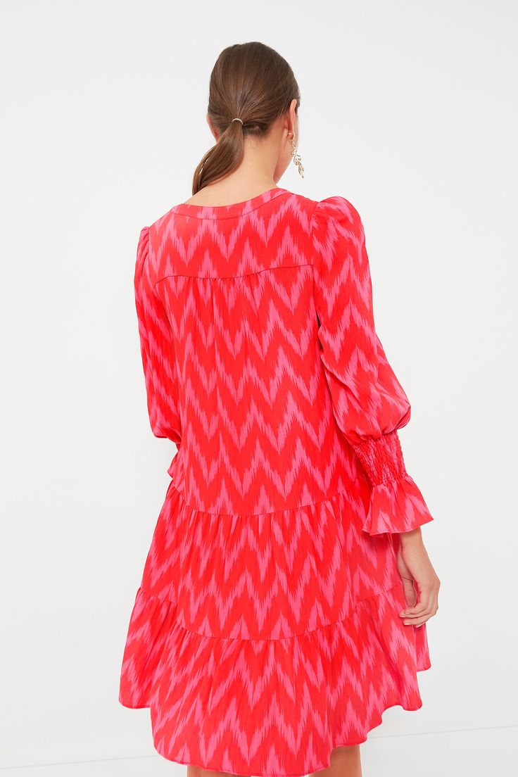 A Tuckernuck fan favorite, the Hot Pink Ikat Kenzo Dress is the mini of the season. Featuring feminine flutter smocked cuffs, a V-neckline and a loose empire waist, this is the most flattering flirty frock! Pair with flats for a casual look or dress up with heels and statement earrings for date night. V-neckline Long sleeves Elasticated ruffle cuff Swing shape Tiered skirt Mini length Material: 75% Rayon, 25% Nylon Care: Hand wash cold Flowy Ruffle Dress With Bishop Sleeves, Chic Tiered Dress With Smocked Cuffs, Casual Dress With Elastic Bishop Sleeves, Casual Dress With Bishop Elastic Sleeves, Casual Dresses With Bishop Elastic Sleeves, Summer Dresses With Smocked Cuffs And Ruffle Sleeves, Casual Dress With Bishop Pleated Sleeves, Fall Dresses With Ruffle Hem And Bishop Sleeves, Brunch Dresses With Smock And Ruffle Sleeve