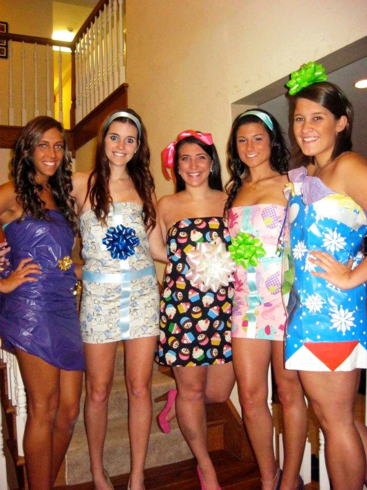 four women in bathing suits posing for the camera with one woman wearing a flower headband