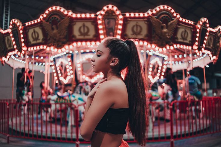 a woman standing in front of a merry go round