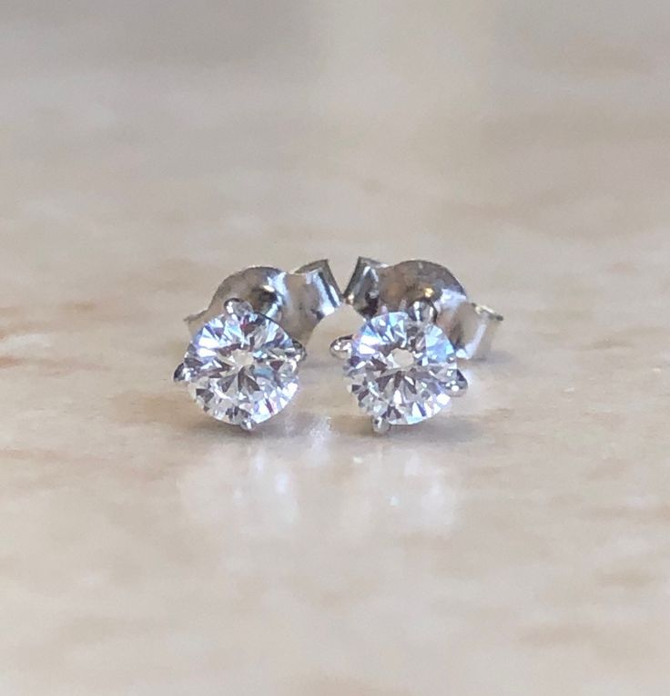 A classic and shiny pair of four prong diamond stud earrings crafted in 14 karat white gold with push backs for all gift occasions!! It features two round perfectly cut and calibrated natural diamonds weighing 0.10 carat each, D-F color VVS clarity.  These can be made in any diamond sizes, in 14 and 18 karat yellow or white gold, and platinum.  We also offer them separately for piercing use.  Birthstone: April. Condition: Excellent, New. - 14 day return policy, no questions asked. - Free insured Anniversary Cluster Earrings With Brilliant Cut Sterling Silver, Anniversary Sterling Silver Cluster Earrings With Brilliant Cut, Sterling Silver Cluster Earrings With Brilliant Cut For Anniversary, Anniversary Diamond Cut Sterling Silver Cluster Earrings, Anniversary Sterling Silver Diamond Cut Cluster Earrings, Sterling Silver Cluster Earrings For Anniversary, Platinum White Gold Bridal Earrings For Gift, Brilliant Cut Platinum Earrings As Gift, Brilliant Cut Platinum Earrings For Gift