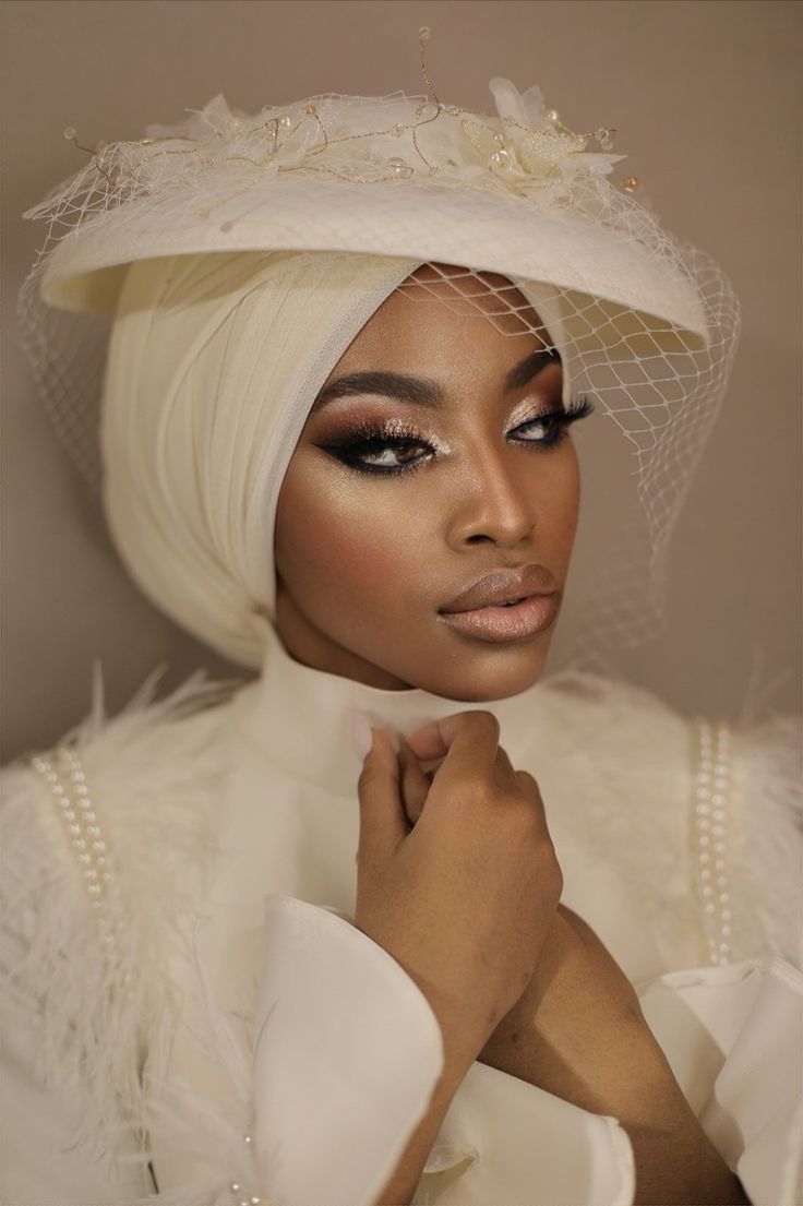 a woman in a white dress and veil with her hands on her chest, posing for the camera