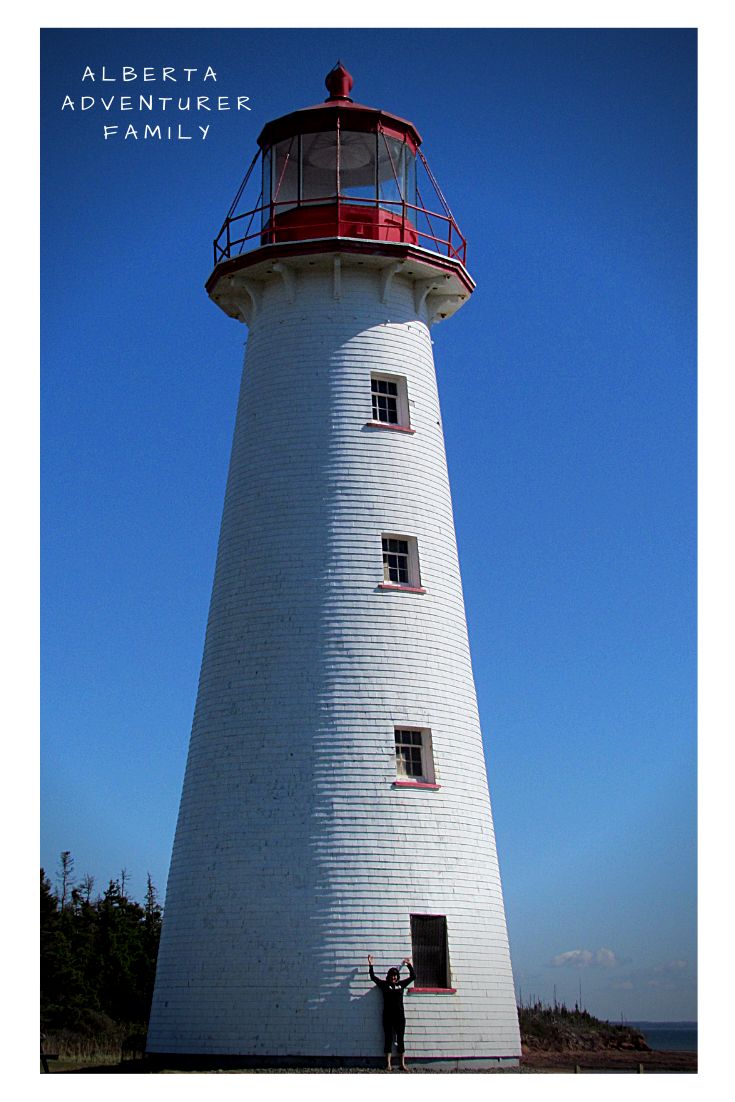 a man standing in front of a white and red lighthouse