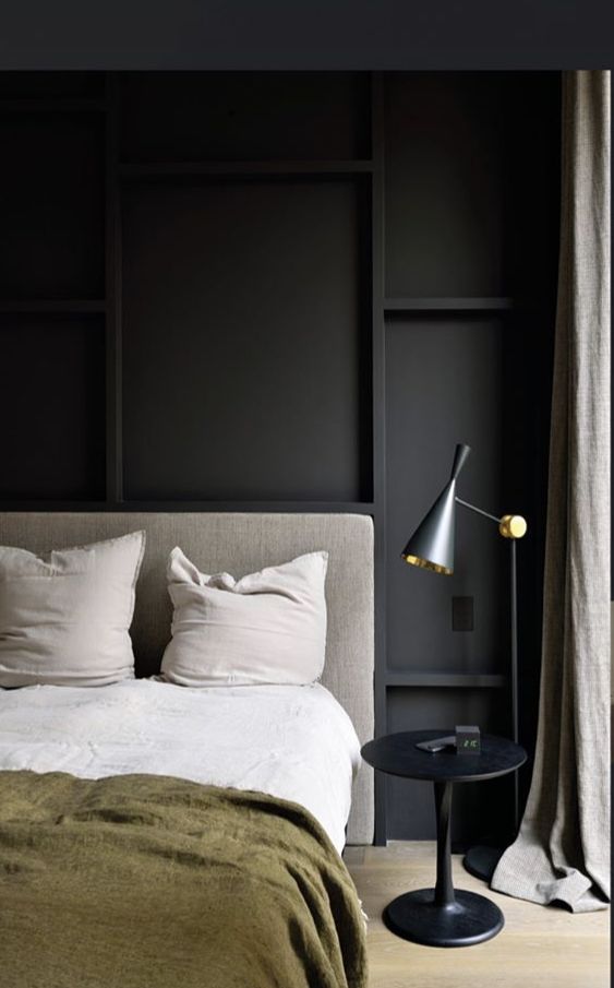 a bedroom with black walls and white bedding