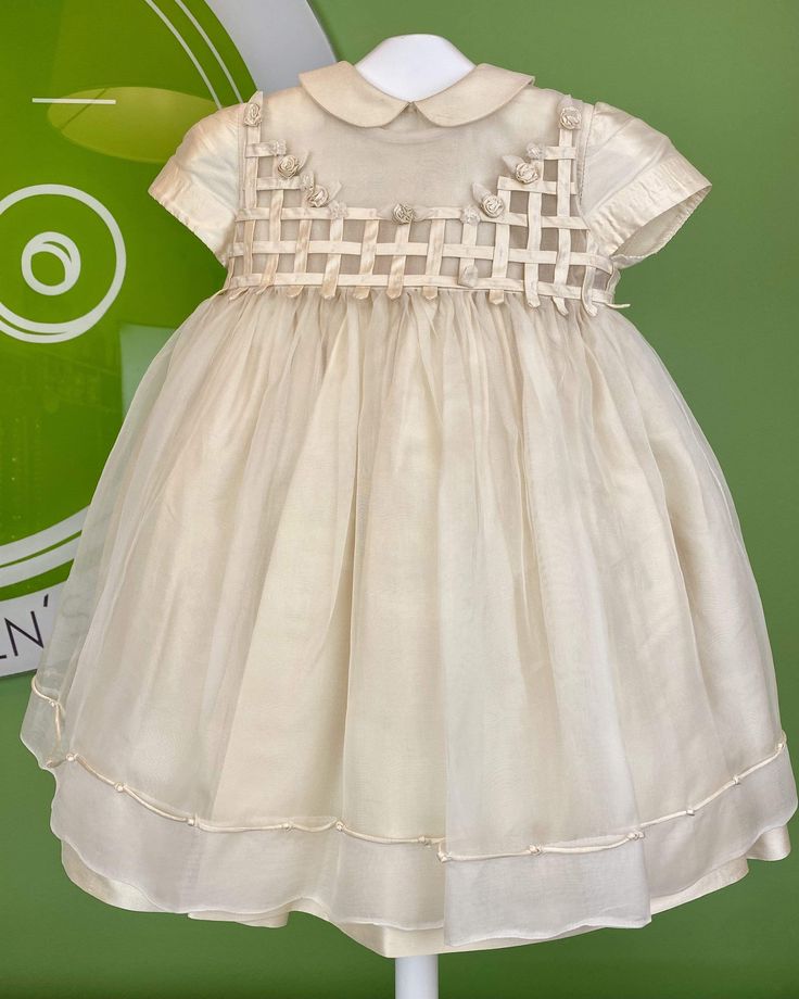 An elegant and exquisite dress for baby girls, made with two layers of dress. One is made with silk and is en empire cut, which is covered by a second layer made with lightweight organza. This second layer has a cute detail with silk and embroidered flowers. The layers have buttons on the back for closure and an organza bow. Made in Portugal 20% Polyester 80% Silk Handwash or Dry Clean Final Sale, no exchanges nor returns will be available Elegant Spring Baptism Dress In Organza, Elegant Spring Organza Baptism Dress, Elegant Off-white Baptism Dress With Ruffles, Cream Organza Dress For Summer, Summer Cream Organza Dress, Elegant Cream Baptism Dress For Summer, Elegant Cream Dress For Dress-up Occasion, Elegant Beige Dress For Dress-up Occasions, Spring Cream Organza Dresses