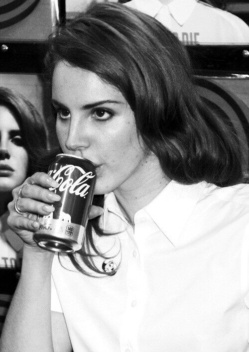 black and white photograph of woman drinking coca cola