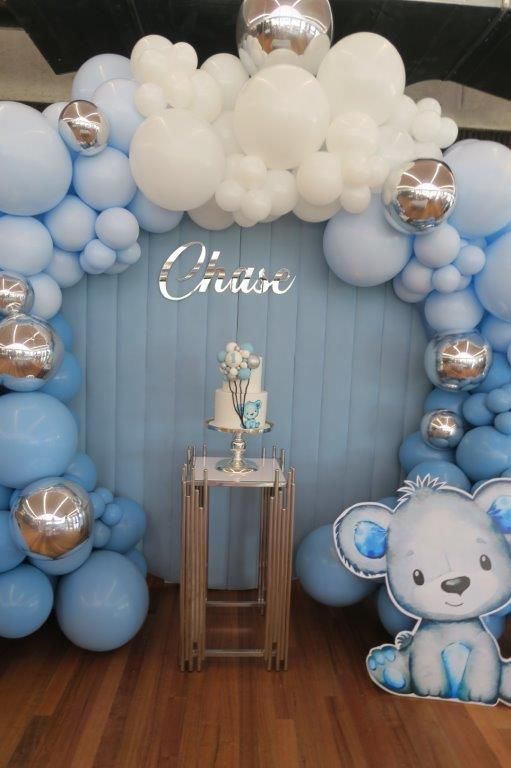 a balloon arch is decorated with blue and white balloons for a baby's first birthday