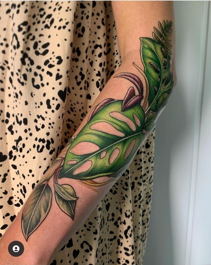 a woman with a green leaf tattoo on her arm