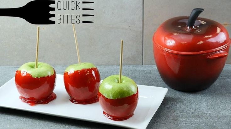 three apples with toothpicks in them on a white plate next to an apple