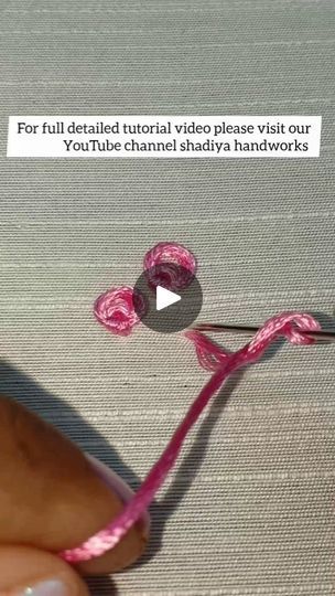 someone is stitching together pink yarn on a piece of fabric