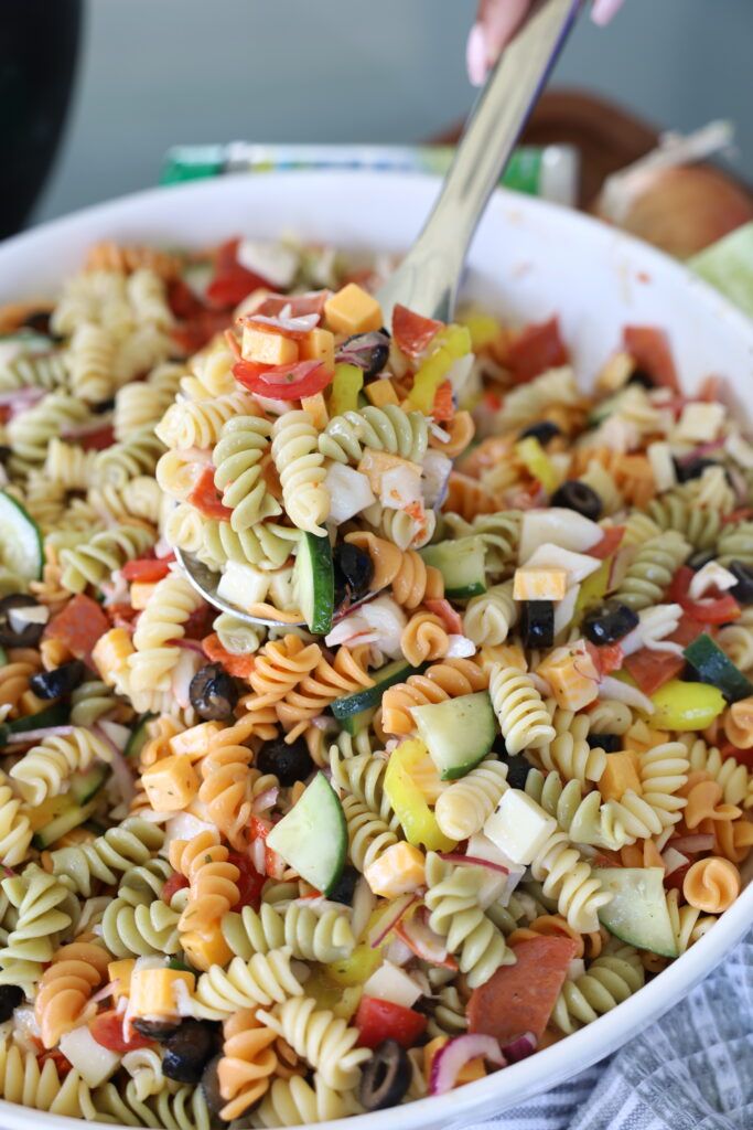 a white bowl filled with pasta salad on top of a table