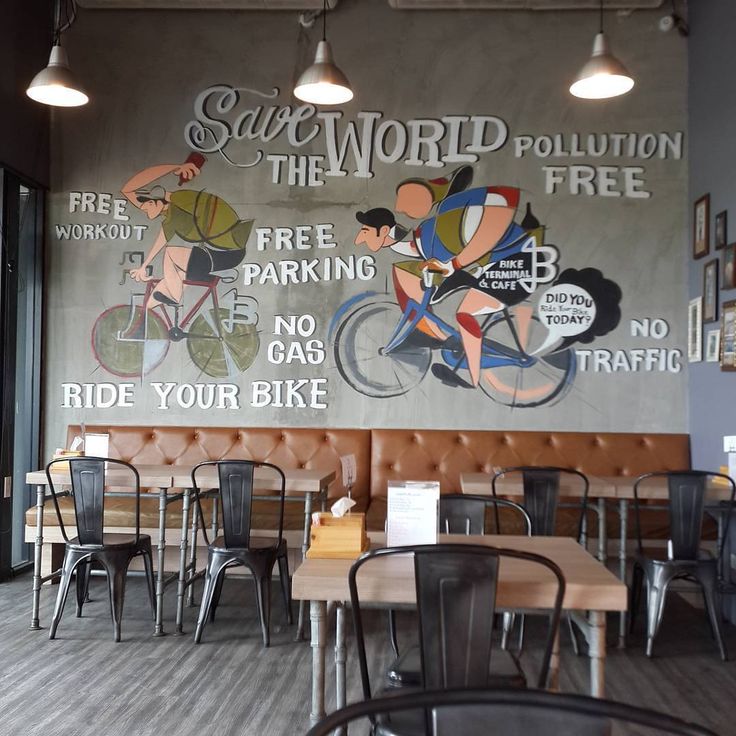 an empty restaurant with tables and chairs in front of a large mural on the wall