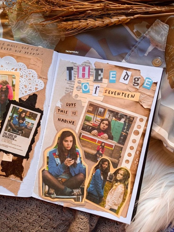 an open book with pictures on it sitting on top of a table next to feathers