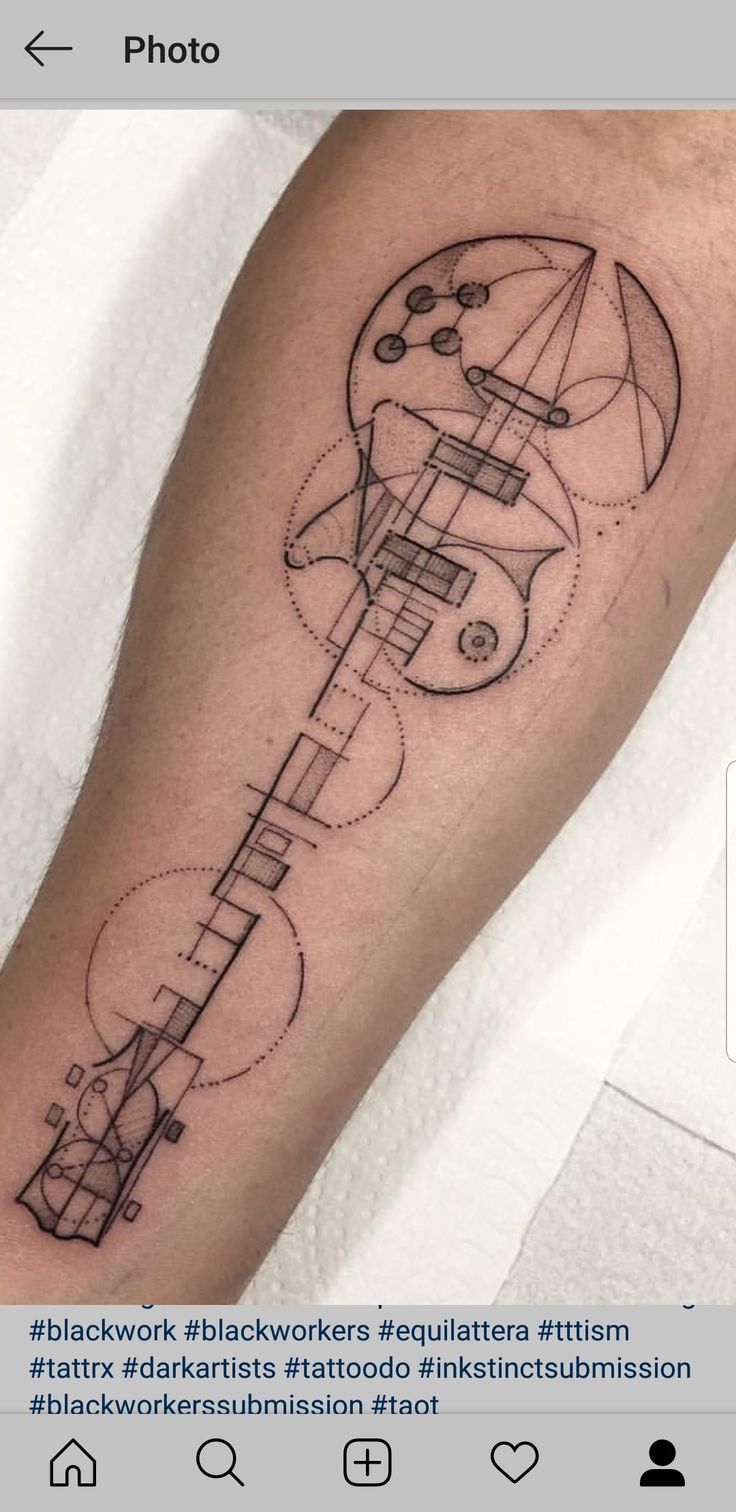 a man's arm with a guitar tattoo on it