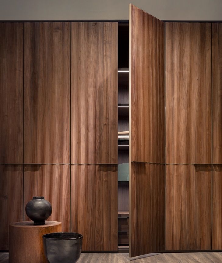 a room with wooden cabinets and black vases