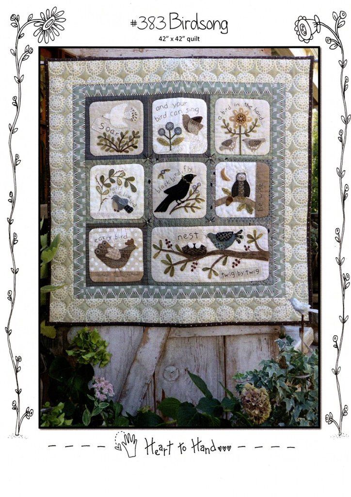 a quilted wall hanging with birds and flowers on it's sides, in the middle