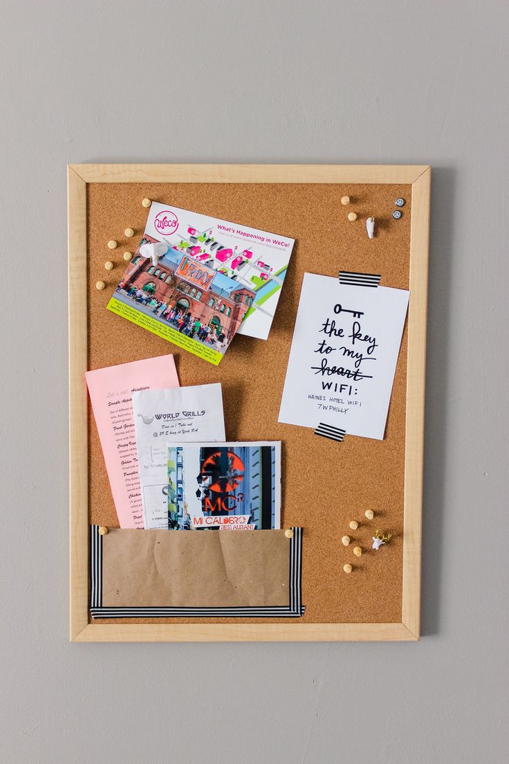 a cork board with some papers and magnets on it