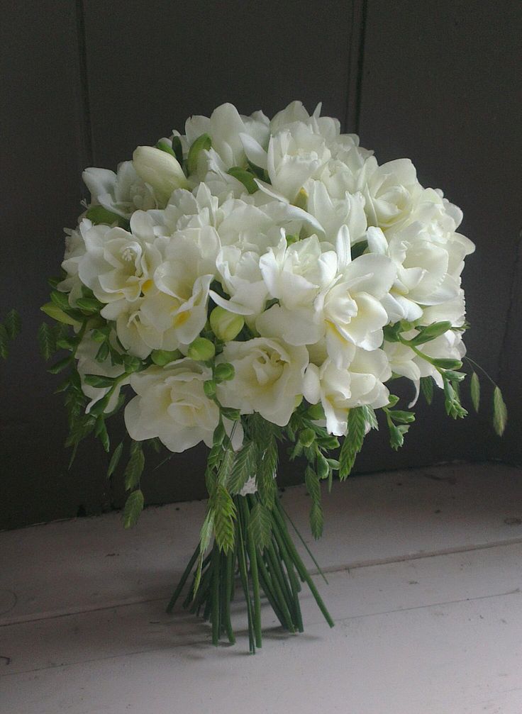 a bouquet of white flowers sitting on top of a table