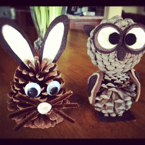 two pinecone shaped animals sitting on top of a wooden table